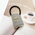 Detail of grey velvet scrunchie with a gold metal bow on high-elastic hair band - Gray