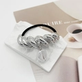 Détail de l'anneau torsadé argenté et pendentif coquillage sur l'élastique noir - Style Pendentif Coquillage / Argent Tressé