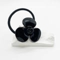 Dettaglio dell'elastico per capelli con fiore nero vintage in acetato su pietra - Nero