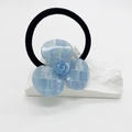 Dettaglio di elastico per capelli a fiore a scacchi blu con finitura lucida - Celeste
