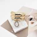 Detail of golden U-shaped hair cuff with a pear-cut crystal drop on a stone background - Model C Double Layer Wide (556C Gold)
