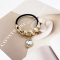 Detailed shot of golden spiral metal bead and heart crystal charm on a black hair tie - Twisted Gold (555-Twisted Gold)