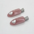 Detail von zwei rosa matten Haarspangen aus Harz mit silbernen Herzen und Entenschnabelclip - Rosa