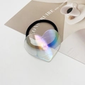 Gros plan d'un élastique à cheveux avec pendentif cœur irisé sur papier artistique - Style Blanc Laser (8)
