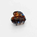 Close-up of tortoise shell heart hair claw clip with golden France Handmade lettering - Dark Brown Floral Pattern