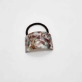 Detail shot of the U-shaped acetate marble pattern hair tie with durable black elastic band - Brown Blue