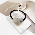 Nahaufnahme von Haargummi mit Herz-Marmor-Resin und funkelnder Gold-Einlage - Gebrochenes Weiß