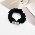 Detailed shot of black scrunchie with crystal butterfly accent and gold buckle - Bow Decoration