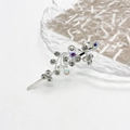 Gedetailleerde close-up van een zilveren haarspeld met glinsterende strass en bloemen - Transparant