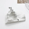 Macro shot of sparkling crystal vine hair clip on minimalist white plaster stand - Clear Rhinestones Silver Clip