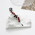 Détail d'une pince à cheveux florale en argent avec cristaux rouges et violets - Rouge