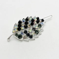 Macro detail of leaf-shaped hair clip featuring colorful rhinestones on silver metal base - Gray