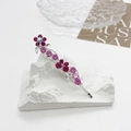 Gros plan sur une barrette en alliage argenté avec strass floraux dégradés rose et violet - Fuchsia