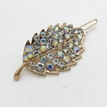 Close-up of golden leaf hair clip with glittering AB rhinestones and cutout details - Clear