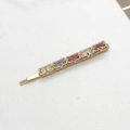 Detail of gold-tone hair clip with five colorful rectangular rhinestones in a gradient - Square Colorful