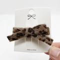 Detailaufnahme der flauschigen Haarklammer mit Leopardenmuster und Schleifendesign - Leopardenmuster