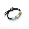 Coletero elástico negro con cuentas de opalo azul y verde y detalles dorados - Azul claro