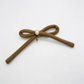 Detail of a brown handmade bow hair clip featuring a white pearl with a metallic beaded edge - Khaki