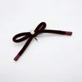 Detalle del lazo de terciopelo burdeos con una perla artificial de borde dorado elegante - Rojo Vino Flocado
