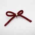 Detail of red fabric bow hairclip featuring a white pearl and golden metal base - Red