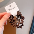 Brown and beige wavy woven hair band with high elasticity on a retail display card - Dark Brown