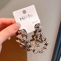Brown and khaki spiral hair bands set on display card held by hand with warm vibe - Khaki