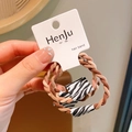 Set van 2 bruine gedraaide haarelastiekjes met zebrapatroon labels voor hoge paardenstaart - Koffie Twist