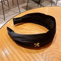Elegante diadema de terciopelo negro con nudo y un pequeño lazo dorado metálico - Negro