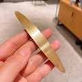 Detailed view of long brushed gold metal spring hair clip with matte texture - Gold