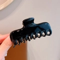 Glossy black rectangular acrylic claw clip held by hand to show medium size and shine - Black