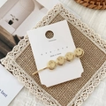 Close-up of golden hair clip with four smiley face charms on a branded display card - Four Smiley Faces (C296)