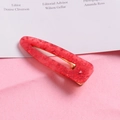 Detail view of red glitter resin hair clip with gold metal snap buckle and texture - Waterdrop-Red