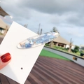 Dreamy blue seashell glitter resin hair clip with shiny shell fragments on white card - Oval Blue