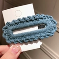 Blue knit floral hairpin with wavy edges and silver metal clip on white card display - Blue
