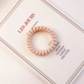 Pastellrosa Spiral-Haargummi mit mattem Finish auf minimalistischer Karte - Hellrosa