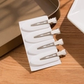 Set of 4 white seamless makeup hair clips with metal base on wooden background - White