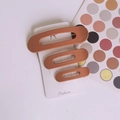 Set di tre fermagli per capelli opachi color terracotta in varie dimensioni su carta - Arancione