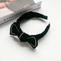 Elegant black velvet headband with a golden braided bow on a minimalist white background - Black Bow Headband