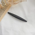 Barrette à ressort minimaliste noir mat sur un fond en tissu élégant - Café Foncé