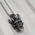 Collar con colgante de calavera punk vintage en acero plateado sobre fondo de madera - Solo colgante