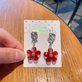 Kids clip-on earrings featuring red glitter flower pendants and heart-shaped gems - Flower