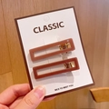 Detail of two brown acrylic rectangular hair clips with gold metal base on a white card - Square Coffee Hair Clips