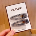 Detailed close-up of two blue marble texture acrylic hair clips on a classic display card - Gray Floral Hair Clips