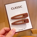 Close-up of brown acrylic teardrop hair clips on classic white display card - Cloud Hair Clip