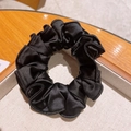 Elegante elastico per capelli in raso nero con texture lucida in un vassoio di legno - Nero