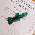 Teal green acetate bow hair clip with a red center ring and France Handmade text - Lake Green