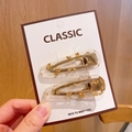Set of two clear acrylic hair clips with gold leaf flakes on a white display card - Gold Hair Clip