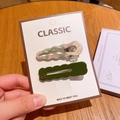 Set of pearl white and dark green wavy candy-colored metal hair clips on a card - Dark Green and Pearlescent White / Dark Green