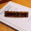 Classic tortoise shell hair clip with gold diamond accent on white book background - Blue-Brown
