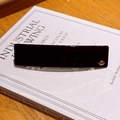 Classic black rectangular tortoiseshell hair clip with golden geometric logo detail - Black
